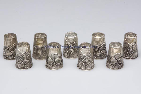 PORTUGUESE STERLING SILVER THIMBLES, LOT OF NINE: PORTUGUESE STERLING SILVER THIMBLES, LOT OF nine, each with various relief patterns comprising of four angel, two Welsh dragon, two with Ivy band and shamrock, and a thistle pattern. 20th century. 1" 