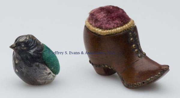 FIGURAL PIN CUSHIONS, LOT OF TWO: FIGURAL PIN CUSHIONS, LOT OF TWO, consisting of a wooden boot with brass rivets and pink velvet cushion; and a sterling silver chick with unidentified hallmarks and "AN" in a shield. Late 19th/early 2
