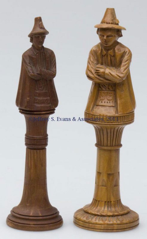 CARVED WOODEN FIGURAL NEEDLE CASES, LOT OF TWO: CARVED WOODEN FIGURAL NEEDLE CASES, LOT OF TWO, depicting Tyrolean figures, opening at feet with a cylinder for needles. Third quarter 19th century. 4 1/8" HOA, 1 1/8" D base, and 4 3/8" HOA, 1 1/4" D