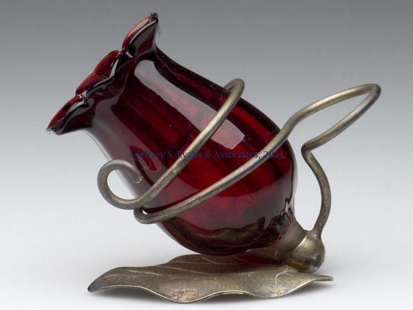 FIGURAL GLASS TOOTHPICK HOLDER: FIGURAL GLASS TOOTHPICK HOLDER, deep red flower-form holder fitted in a silver-plate frame with leaf base, frame impressed "E. P. N. S.". Late 19th/early 20th century. 3 1/8" H, 3 3/4" L. Literature: