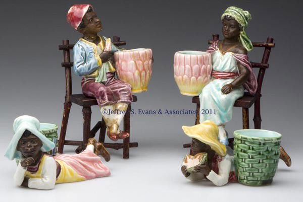 CONTINENTAL MAJOLICA BLACK AMERICANA TOOTHPICK HOL: CONTINENTAL MAJOLICA BLACK AMERICANA TOOTHPICK HOLDERS, LOT OF FOUR, comprised of a boy and girl each sitting on a wooden side chair and two recumbent examples, various impressed numbers on bases. Lat
