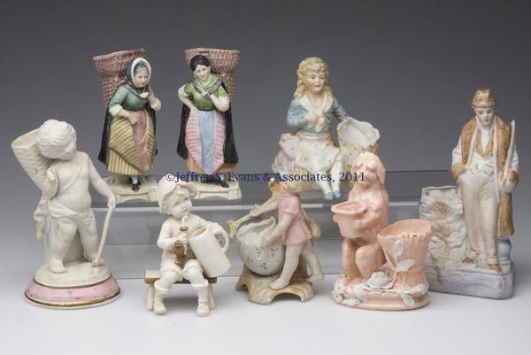 CONTINENTAL BISQUE AND CERAMIC FIGURAL TOOTHPICK /: CONTINENTAL BISQUE AND CERAMIC FIGURAL TOOTHPICK / MATCH HOLDERS, LOT OF EIGHT, comprised of a cupid; two ladies with baskets on back; a dog with applied floral decoration; a gentleman with bear; a yo