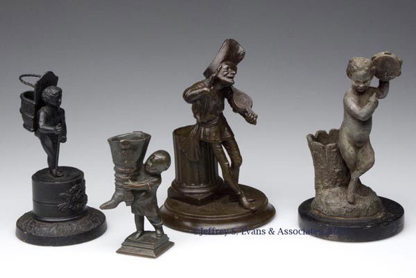 VARIOUS METAL FIGURAL TOOTHPICK HOLDERS, LOT OF FO: VARIOUS METAL FIGURAL TOOTHPICK HOLDERS, LOT OF FOUR, comprised of a child holding a large boot, a musician with unidentified markings to base , and two examples with a young boy. 19th/20th century. 4