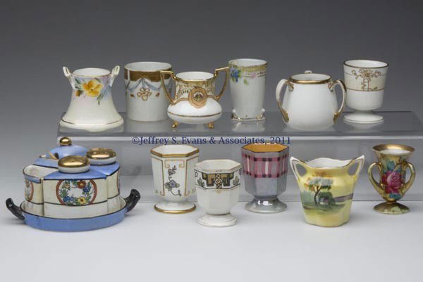 NIPPON AND NORITAKE CERAMIC TOOTHPICK HOLDERS, LOT: NIPPON AND NORITAKE CERAMIC TOOTHPICK HOLDERS, LOT OF 11, various floral, scenic and gilt decorations, comprised of seven Nippon, two Noritake, and two unmarked examples. Together with a Chikaramachi