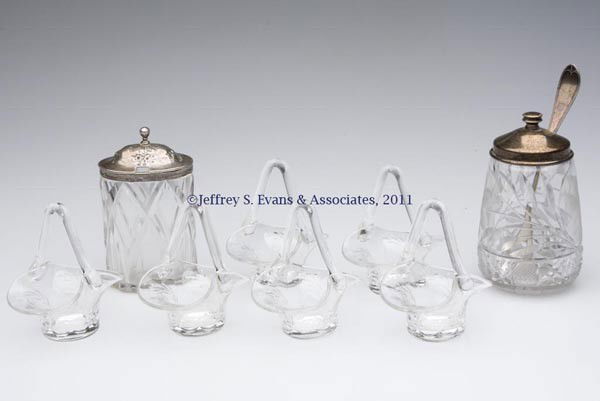CUT GLASS CONDIMENT ARTICLES, LOT OF EIGHT: CUT GLASS CONDIMENT ARTICLES, LOT OF EIGHT, colorless, comprising a set of six figural basket salt cellars, each with cut floral pattern, applied handle, polished bases and terminals; and two condimen