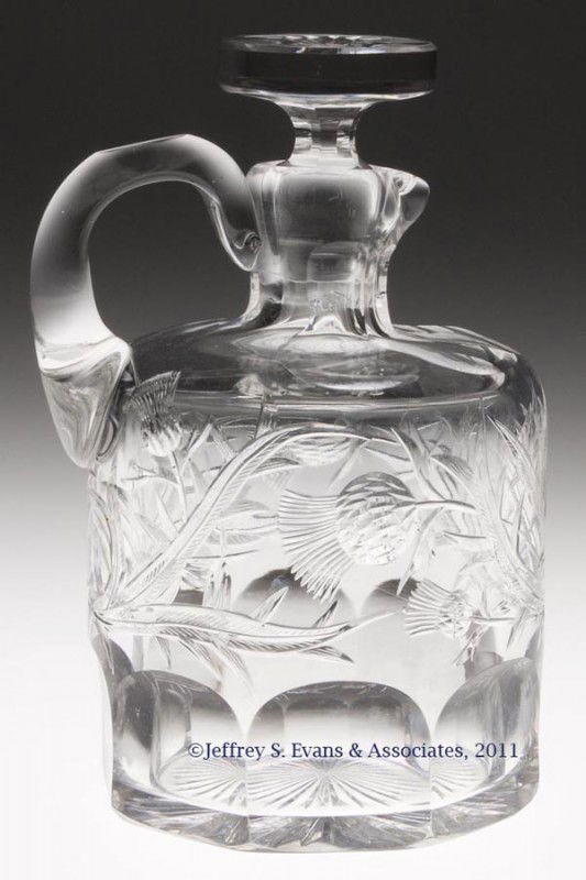 INTAGLIO CUT GLASS WHISKEY JUG: INTAGLIO CUT GLASS WHISKEY JUG, featuring a thistle pattern above eight cut panels, sunburst to top of stopper and in base. Late 19th/early 20th century. 7 1/2" HOA, 4 1/2" DOA. Provenance: From the c