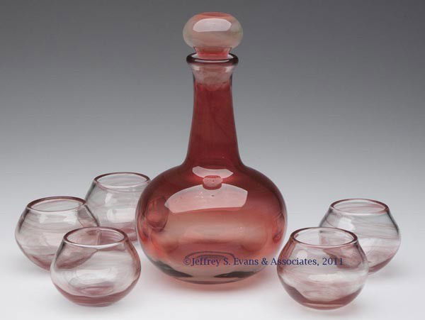 BAKER O'BRIEN STUDIO ART GLASS SIX-PIECE LIQUEUR SE: BAKER O'BRIEN STUDIO ART GLASS SIX-PIECE LIQUEUR SET, comprising a brick red shading to colorless stoppered decanter with a polished pontil mark, and five small lightly swirled glasses, each with poli