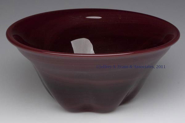 LABINO STUDIO ART GLASS BOWL: LABINO STUDIO ART GLASS BOWL, maroon slag, six slight swells at base, polished table ring and pontil mark, signed and dated "9-1972". Dominick Labino. 1972. 3" H, 6 3/4" DOA.