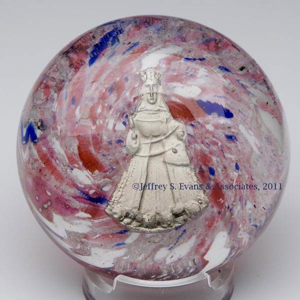 SULPHIDE-TYPE GLASS PAPERWEIGHT: SULPHIDE-TYPE GLASS PAPERWEIGHT, two-part construction, featuring a female saint on a polychrome swirled frit ground, with a rough pontil mark, covered by a colorless glass dome, with a polished ponti