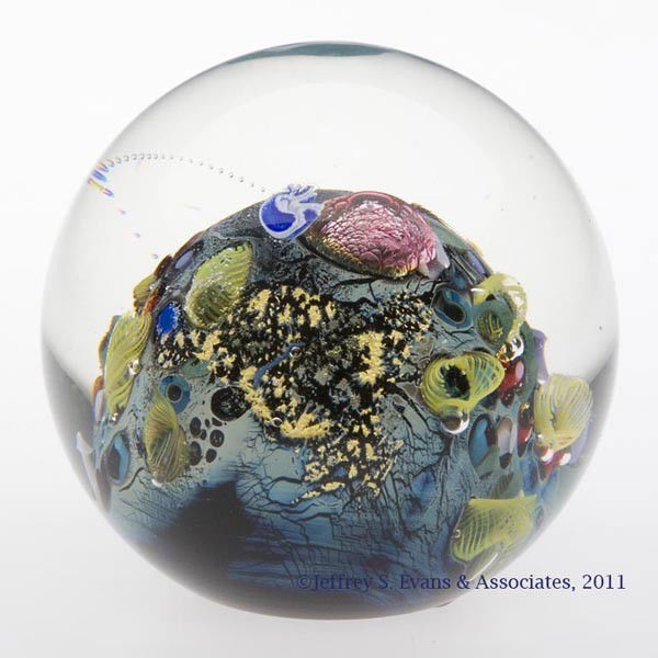 JOSH SIMPSON "INHABITED PLANET" ART GLASS PAPERWEI: JOSH SIMPSON "INHABITED PLANET" ART GLASS PAPERWEIGHT, multiple inclusions, great three-dimensional quality including a flying saucer, polished base, signed and dated "1988", numbered "P-282". Josh Si