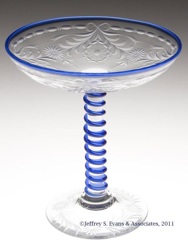 PAIRPOINT ENGRAVED GLASS COMPORT: PAIRPOINT ENGRAVED GLASS COMPORT, colorless with applied blue edge and trim, shape F-290, Wexford decoration, polished pontil mark. Pairpoint Corp. First half 20th century. 6 1/2" H, 6" D. Provenance: