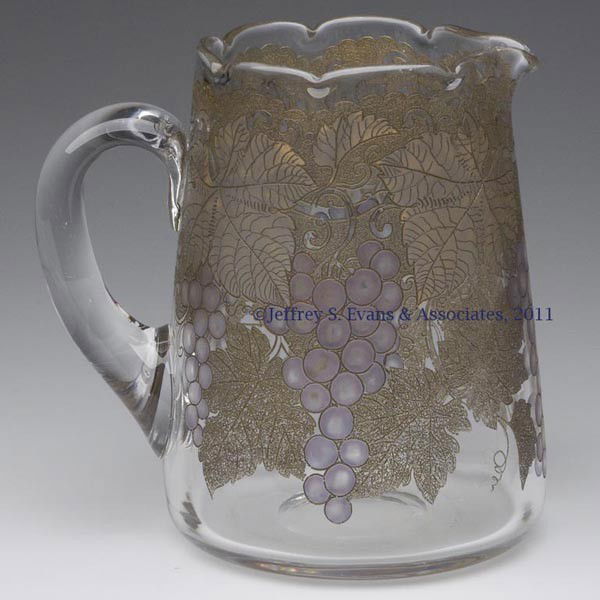 LOCKE ART GLASS GRAPE PATTERN WATER PITCHER: LOCKE ART GLASS GRAPE PATTERN WATER PITCHER, original gilt and purple stained decoration on pattern, squat tankard form with a crimped rim, applied handle, and polished pontil mark, signed "Locke Art"