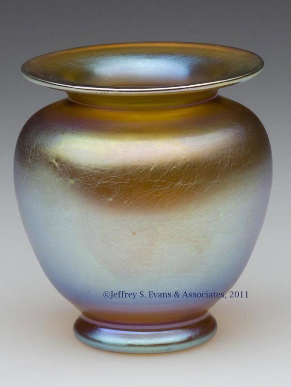 TIFFANY GOLD FAVRILE CABINET VASE: TIFFANY GOLD FAVRILE CABINET VASE, urn-form body with a flared rim and raised on a slight foot, marked with a gold and green foil label only, polished pontil mark and table ring. Attributed to Tiffany