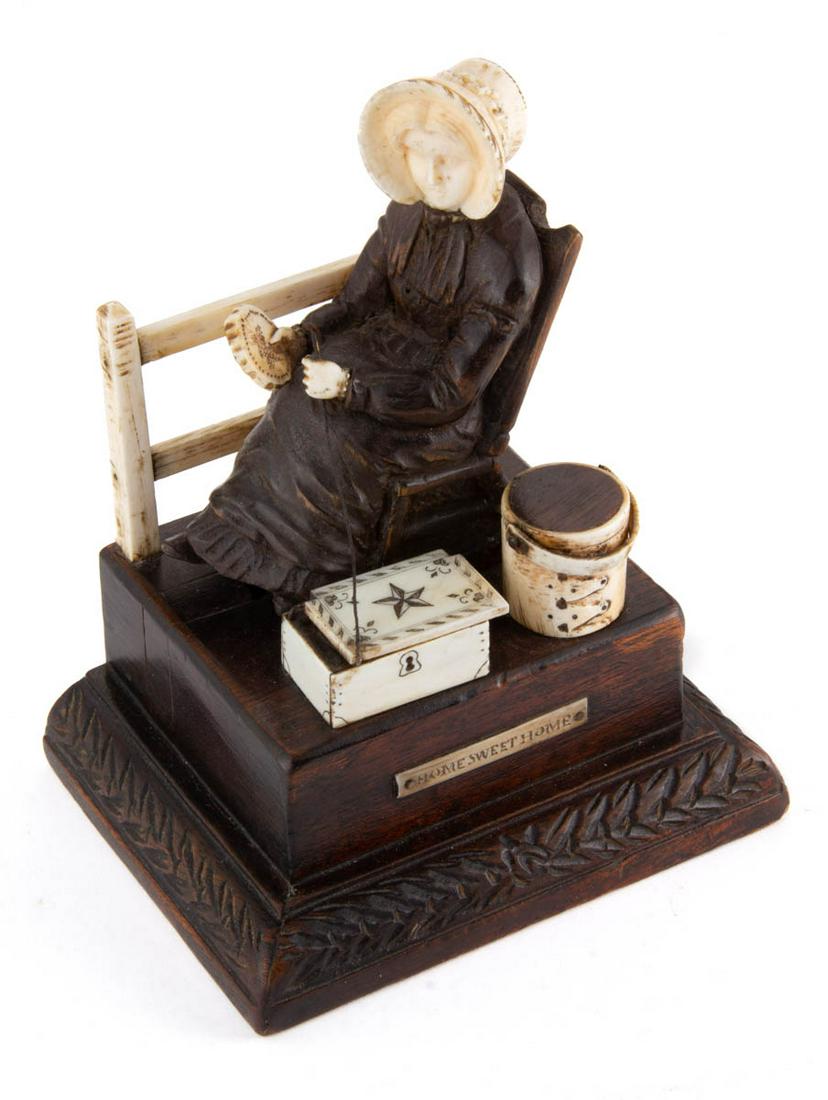 AMERICAN CARVED WOOD AND BONE FIGURAL SEWING AUTOMATON: AMERICAN CARVED WOOD AND BONE FIGURAL SEWING AUTOMATON, square-form base with foliage carvings to edge, depicting a lady in bonnet sitting in a rocking chair doing embroidery work beside a split-rail 