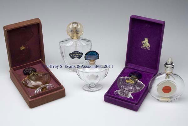 GUERLAIN "SHALIMAR" FRAGRANCE BOTTLES, LOT OF FIVE: GUERLAIN "SHALIMAR" FRAGRANCE BOTTLES, LOT OF FIVE, colorless, comprising three footed examples, one lacking label, each with blue-stained stopper, two in original boxes; a flat round example with con