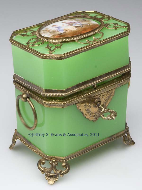 GILT-METAL AND OPALINE COLOGNE BOTTLE CASKET: GILT-METAL AND OPALINE COLOGNE BOTTLE CASKET, green opaline, containing two matching bottles, each with gilt-metal fittings, topped by a hand-painted porcelain portrait, and with original interior sto