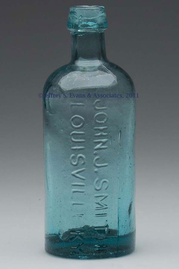 KENTUCKY MEDICINE BOTTLE: KENTUCKY MEDICINE BOTTLE, strong blue green, cylindrical form embossed "JOHN. J. SMITH / LOUISVILLE KY." vertically, applied sloping mouth, large graphite pontil mark. United States. 1850-1870. 5 3/4"