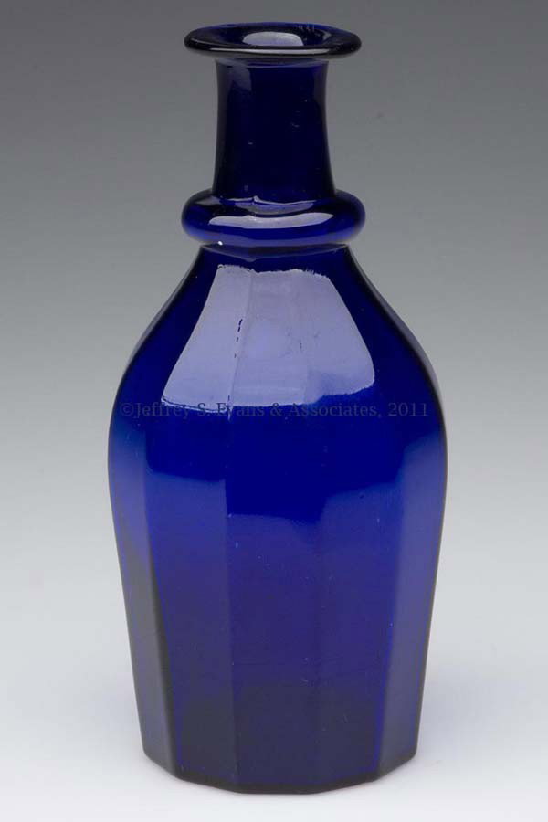 BLOWN-MOLDED PANELED CRUET OR TOILET BOTTLE: BLOWN-MOLDED PANELED CRUET OR TOILET BOTTLE, deep cobalt blue, plain base. Boston & Sandwich Glass Co. 1835-1850. 5 7/8" H. Literature: B & K I, fig. 1273. Provenance: Property of Art & Kathy Green.