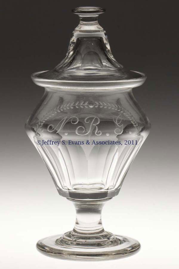 CUT BROAD FLUTE SUGAR URN WITH COVER: CUT BROAD FLUTE SUGAR URN WITH COVER, colorless, truncated conical bowl with a sharp shoulder and slightly galleried rim, shoulder engraved with "N. R. G." below a laurel arch, raised on a spool-like