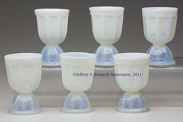 SET OF SIX PRESSED EIGHT-PANEL DOUBLE EGG CUPS: SET OF SIX PRESSED EIGHT-PANEL DOUBLE EGG CUPS, fiery opalescent, high lead glass, each featuring an unpatterned band at rim and a slight foot. United States. 1850-1870. 3 5/8" H, 2 3/8" D rim, 2 1/4"