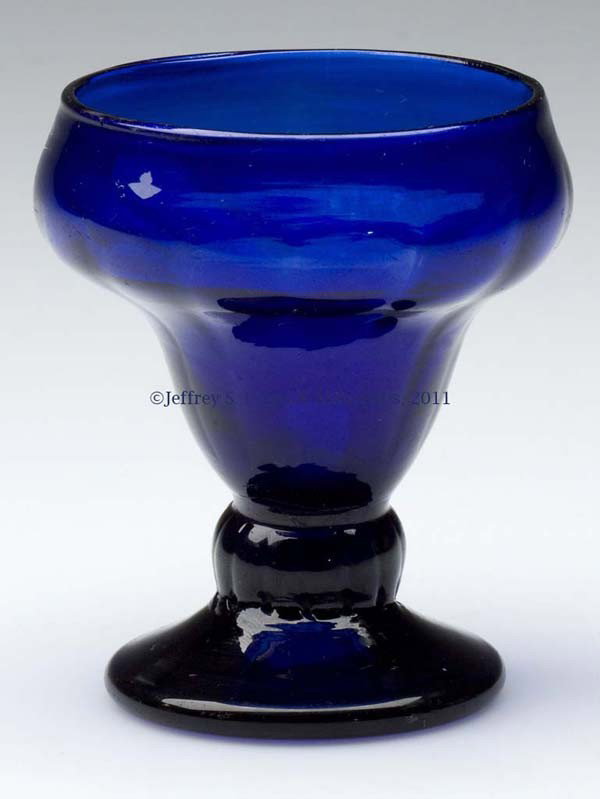 PATTERN-MOLDED FOOTED SALT: PATTERN-MOLDED FOOTED SALT, cobalt blue, double-ogee form bowl molded with 14 vertical ribs, raised on a short ribbed stem and thick sloping foot with a rough pontil mark. United States or England. 17