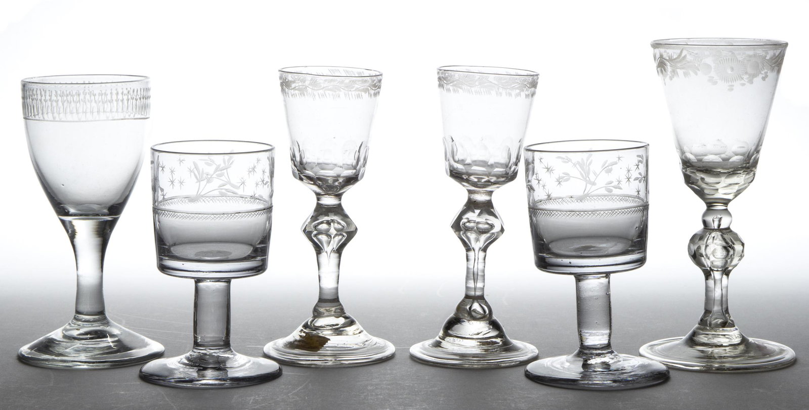 FREE-BLOWN, ENGRAVED, AND CUT WINES, LOT OF SIX: FREE-BLOWN, ENGRAVED, AND CUT WINES, LOT OF SIX, colorless, including two pairs with one having short cylindrical bowls with matching engraved decoration, and a pair with bucket bowls and cut complex 