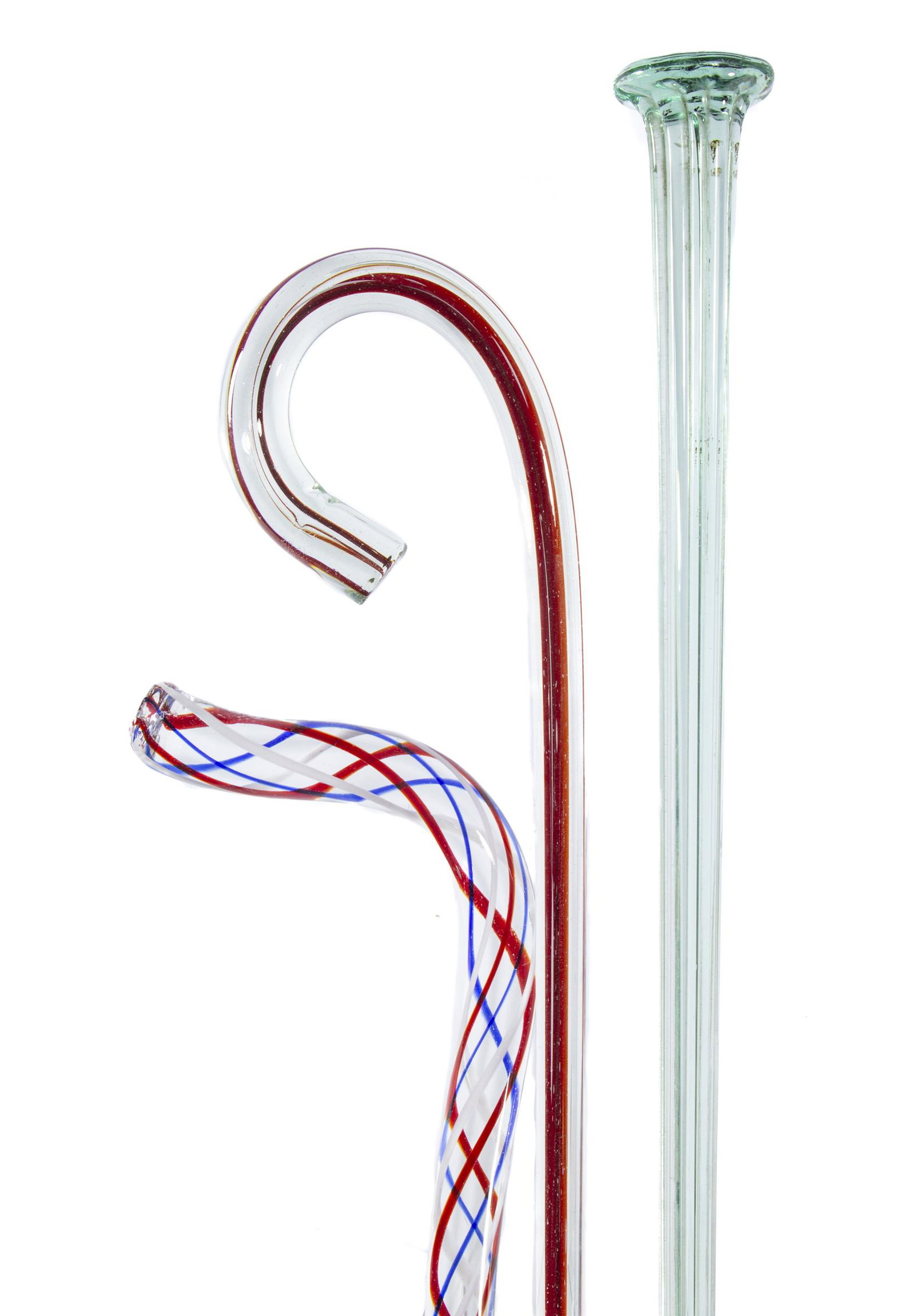 FREE-BLOWN GLASS WALKING STICKS / CANES, LOT OF THREE: FREE-BLOWN GLASS WALKING STICKS / CANES, LOT OF THREE, comprising a colorless cased ruby cane, a red, white, and blue swirled cane, and an aquamarine walking stick. Various makers. 19th century. 35" t