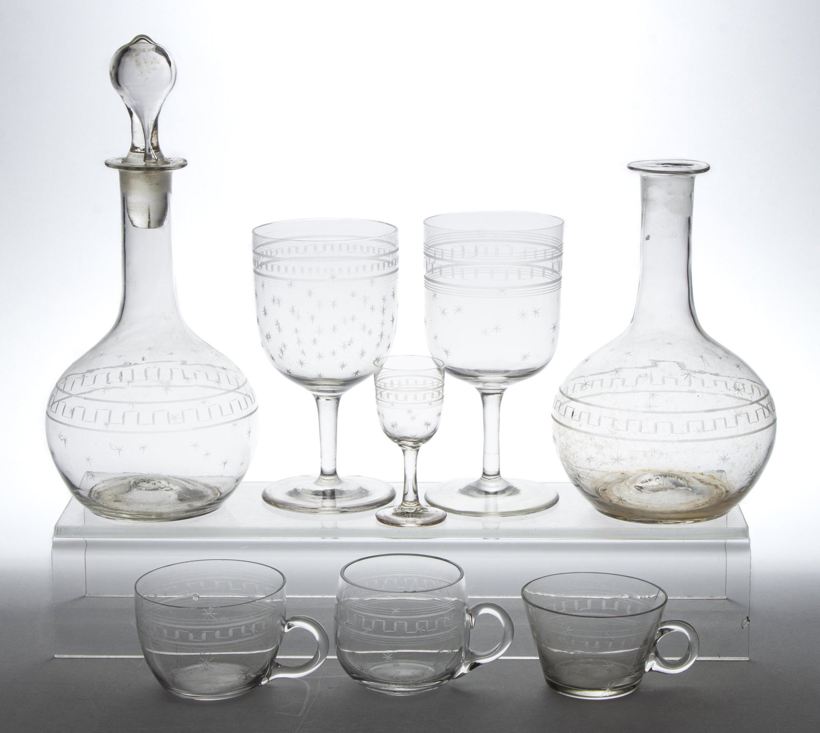 LATE BLOWN AND ENGRAVED ROMAN KEY AND STAR DRINKING VESSELS, LOT OF 34: LATE BLOWN AND ENGRAVED ROMAN KEY AND STAR DRINKING VESSELS, LOT OF 34, colorless, comprising two decanters with one lacking a stopper, eight goblets, two cordials, and 22 punch cups. Boston & Sandwic