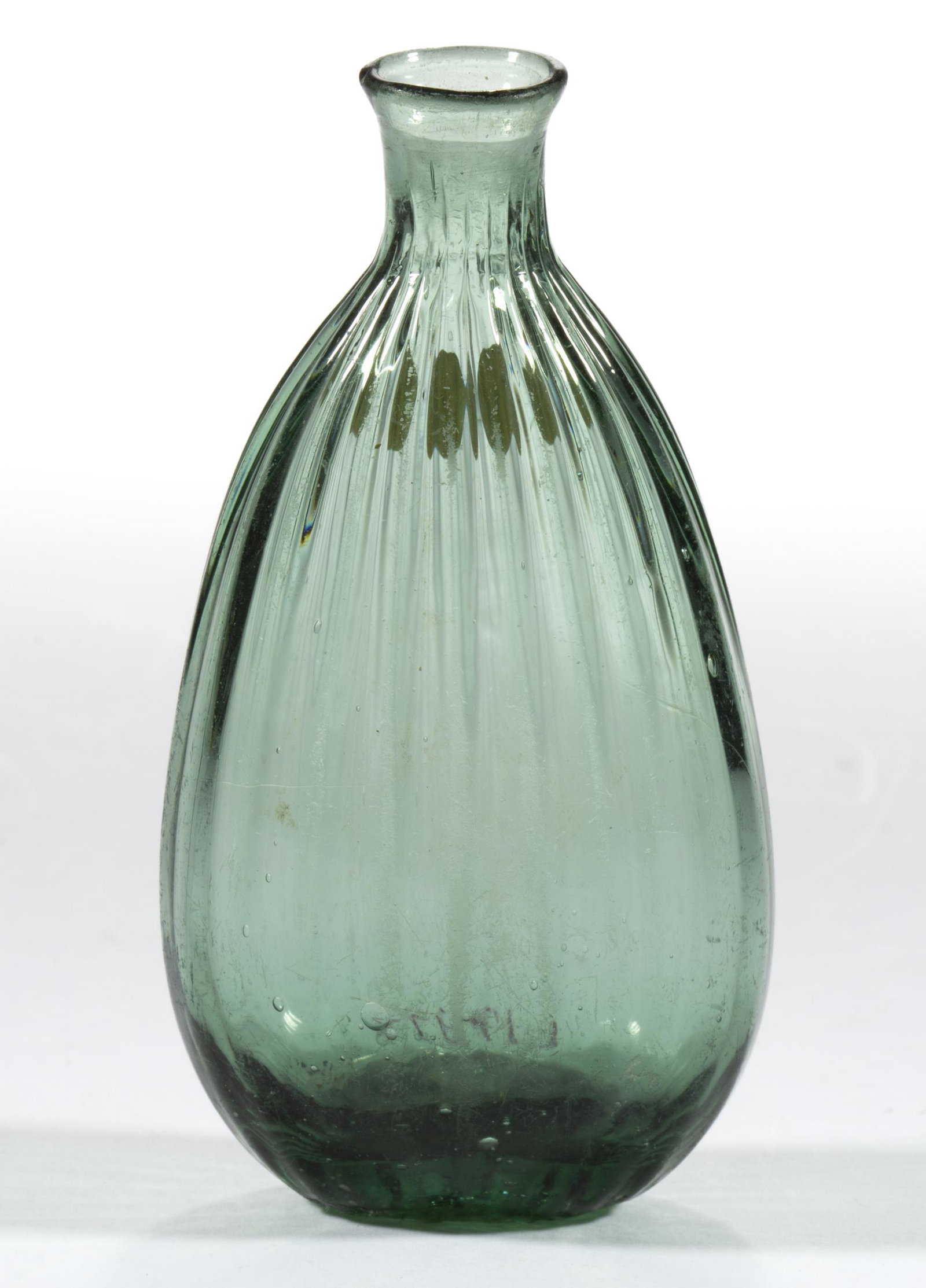 PATTERN-MOLDED POCKET FLASK: PATTERN-MOLDED POCKET FLASK, pale green, ovoid form with 24 vertical ribs, rough pontil mark. Midwestern or Eastern United States. Late 18th/early 19th century. 4 1/4" H, 2 1/8" DOA. Literature: McKea