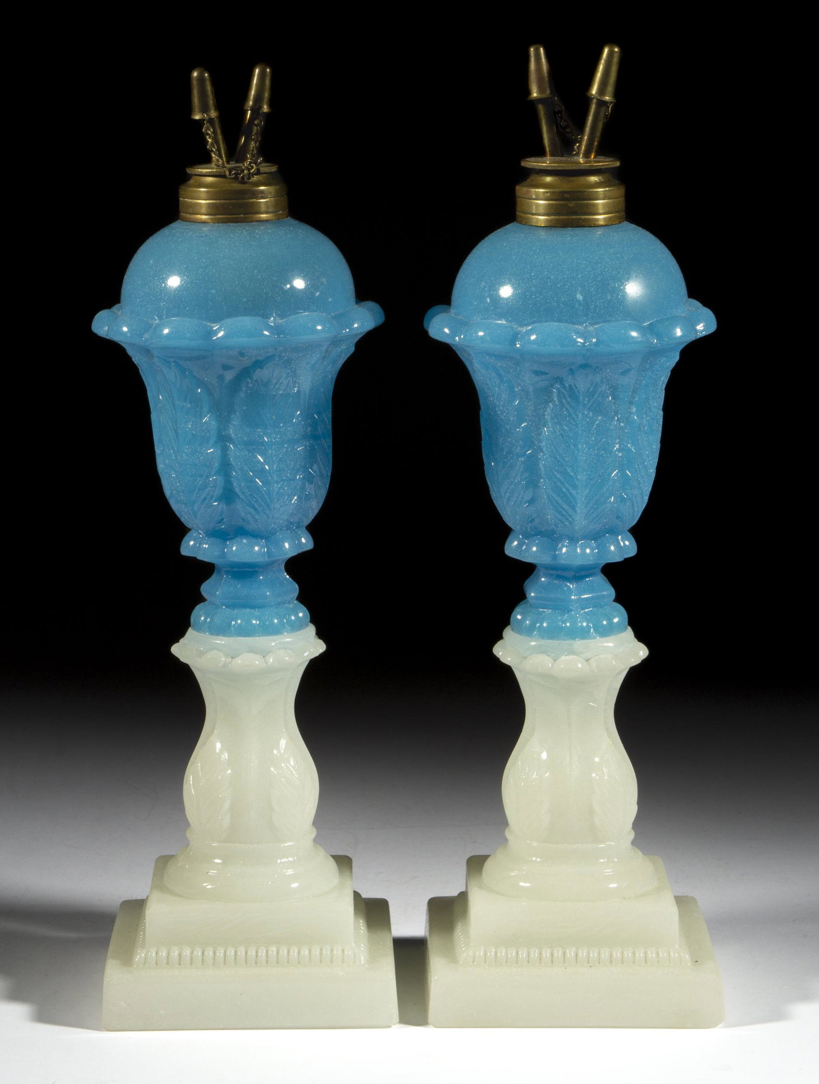 PRESSED ACANTHUS LEAF PAIR OF WHALE OIL / FLUID STAND LAMPS: PRESSED ACANTHUS LEAF PAIR OF WHALE OIL / FLUID STAND LAMPS, translucent starch blue above alabaster/clambroth, small size, dome-top font with 12 protruding petals below the shoulder and a short hexag