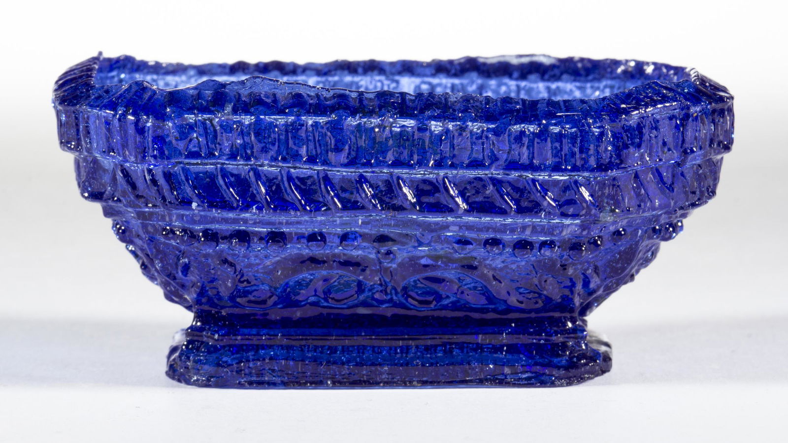 OO UNLISTED VARIANT OCTAGON OBLONG PRESSED OPEN SALT: OO UNLISTED VARIANT OCTAGON OBLONG PRESSED OPEN SALT, medium blue, serrated rope rim with diagonals below the second band of serrations, added lower beads, base covered with beads. Probably extremely