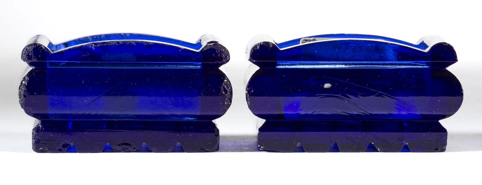 HEAVY LOW-LYING SOFA-FORM PAIR OF OPEN SALTS, LOT OF TWO: HEAVY LOW-LYING SOFA-FORM PAIR OF OPEN SALTS, LOT OF TWO, cobalt blue, each having a heavy block base. United States. 1840-1860. 1 3/4" H, 1 7/8" x 3".Provenance: From the collection of Doug Reed, Map