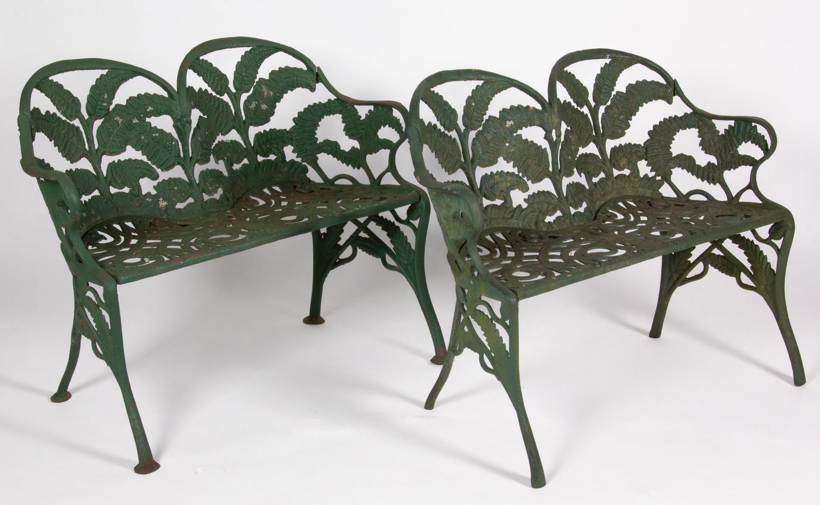 JAMES W. CARR, RICHMOND, VIRGINIA CAST-IRON PAIR OF BENCHES / SETTEES: JAMES W. CARR, RICHMOND, VIRGINIA CAST-IRON PAIR OF BENCHES / SETTEES, fern pattern, cast in four sections, each double-back form with rolled arms, above a scroll-pierced seat, raised on saber-like le