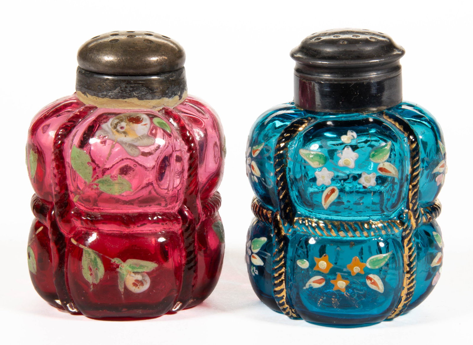 PAIRPOINT BALE ENAMEL-DECORATED SALT AND PEPPER SHAKERS,: PAIRPOINT BALE ENAMEL-DECORATED SALT AND PEPPER SHAKERS, comprising a cranberry and blue example, each having polychrome-enamel decoration with floral design, each having a period two-piece lid. Pairp