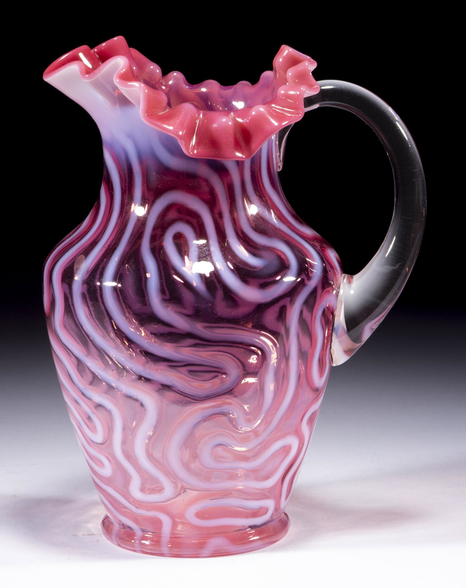 SWIRLING MAZE WATER PITCHER,: SWIRLING MAZE WATER PITCHER, cranberry opalescent, shoulder form with tri-form folded and crimped rim, applied colorless handle. Jefferson Glass Co. Circa 1905. 10" H.Literature: Heacock/Elmore - Opal