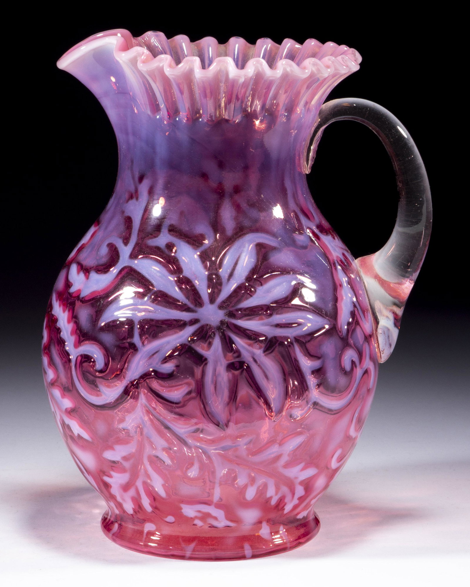 POINSETTIA WATER PITCHER,: POINSETTIA WATER PITCHER, cranberry opalescent, round crimped rim, applied handle with pressed feather design to the upper terminal. H. Northwood Co. Circa 1903. 9 3/4" H. Literature: Heacock/Elmore -