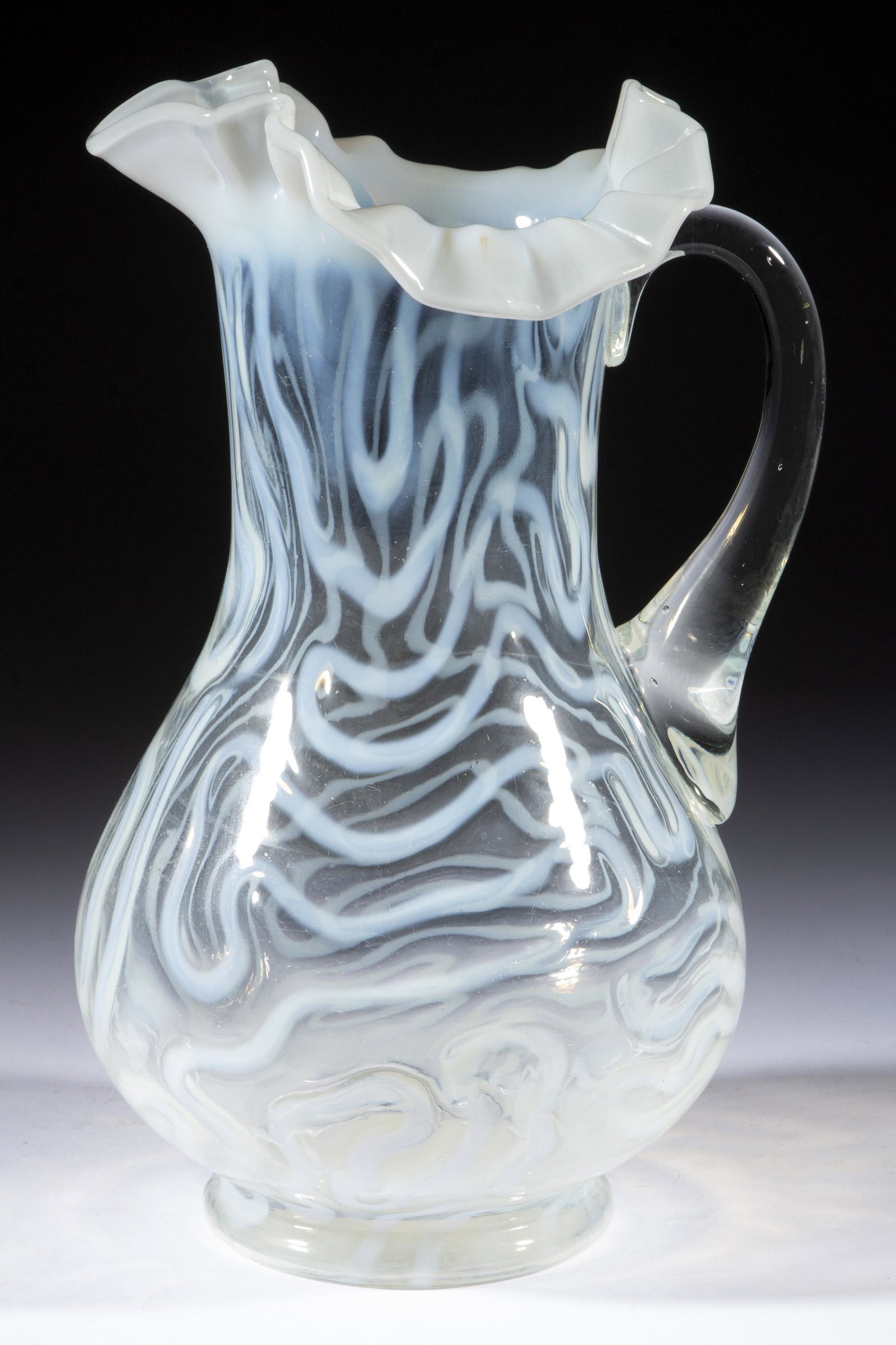SWIRLING MAZE WATER PITCHER,: SWIRLING MAZE WATER PITCHER, colorless opalescent, tooled ruffled rim, applied handle. Jefferson Glass Co. Circa 1905. 11" H.Literature: Parallels Heacock/Elmore - Opalescent Glass A-Z, p. 170, fig. 8