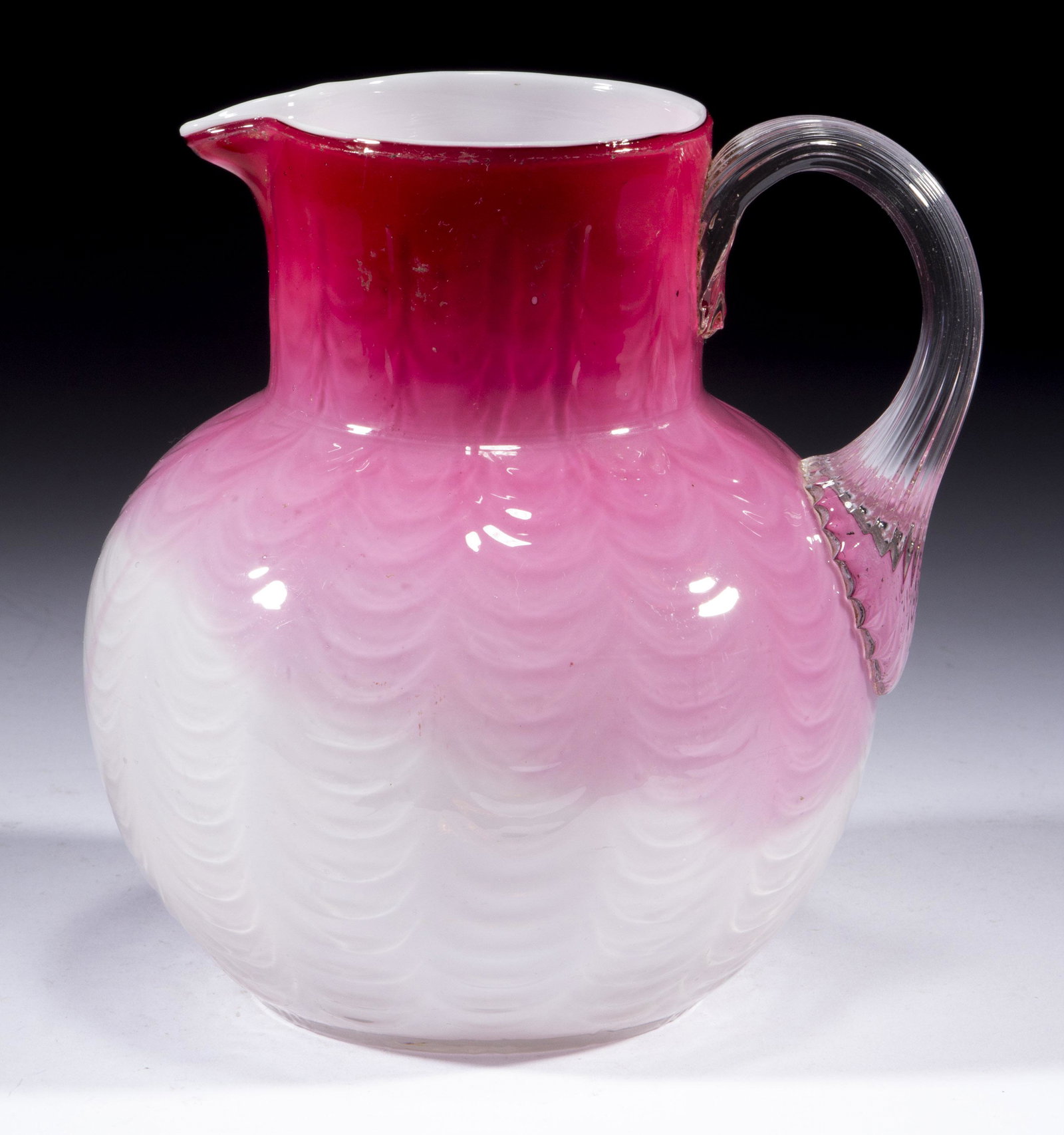 PHOENIX DRAPE-OPTIC PITCHER,: PHOENIX DRAPE-OPTIC PITCHER, rose shaded to white, cased colorless, small globular form with a circular rim, applied colorless reeded handle, polished pontil mark. Phoenix Glass Co. 1883-1888. 6 1/2" 
