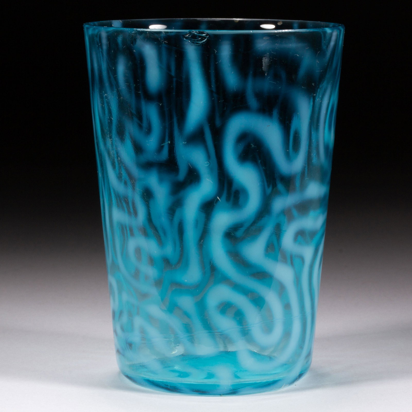SWIRLING MAZE TUMBLER,: SWIRLING MAZE TUMBLER, blue opalescent, factory-polished rim. Jefferson Glass Co. Circa 1905. 4" H.Literature: Parallels Bredehoft - Glass Tumblers, p. 224, middle left.Provenance: The Dean & Leann Li
