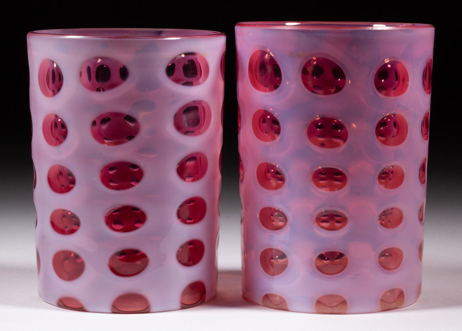 POLKA DOT TUMBLERS, LOT OF TWO,: POLKA DOT TUMBLERS, LOT OF TWO, cranberry opalescent, each having a polished rim. Northwood Glass Co. Pattern introduced 1894. 3 3/4" and 3 7/8" H.Literature: Bredehoft - Glass Tumblers, p. 218, top.