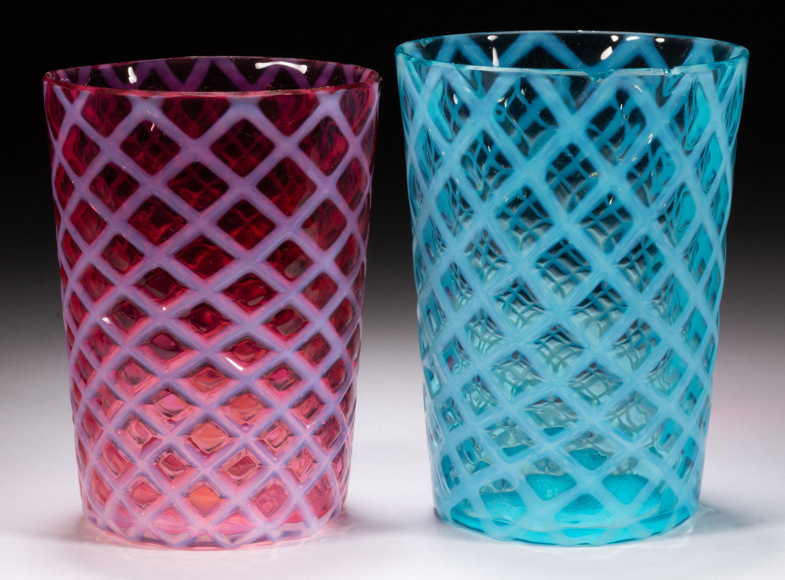 BUBBLE LATTICE TUMBLERS, LOT OF TWO,: BUBBLE LATTICE TUMBLERS, LOT OF TWO, blue opalescent and cranberry opalescent, each having a factory-polished rim. Maker unverified. Late 19th/early 20th century. 3 3/4" to 4" H. Provenance: The Dean 