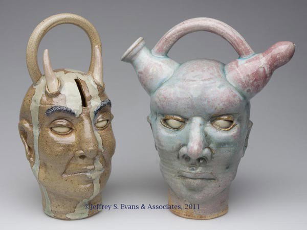 TWO PETER LENZO FACE VESSELS: TWO PETER LENZO FACE VESSELS, comprising an Alien monkey jug inscribed "Back to the / Blind eyes Just / like in the / beginning / 1/23/2004 / LENZO" and a Devil bank inscribed "LENZO / 3-17-2004, each