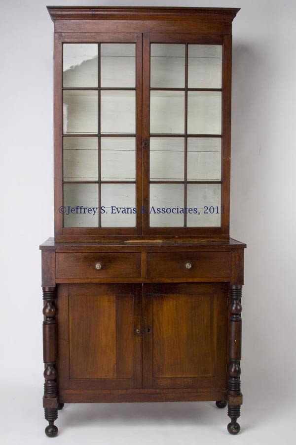 AUGUSTA CO., VA WALNUT JACKSON PRESS: AUGUSTA CO., VA WALNUT JACKSON PRESS, in two sections, the top with a shallow double-cove molded cornice above two 16-pane glazed doors concealing three fixed shelves, the base with two over-hanging d