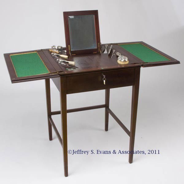 BERKEY & GAY MAHOGANY FITTED DRESSING TABLE: BERKEY & GAY MAHOGANY FITTED DRESSING TABLE, locking, hinged split top opens to lift and reveal an interior fitted with a fold-up mirror and an ornate 13-piece sterling silver dresser set marked for t