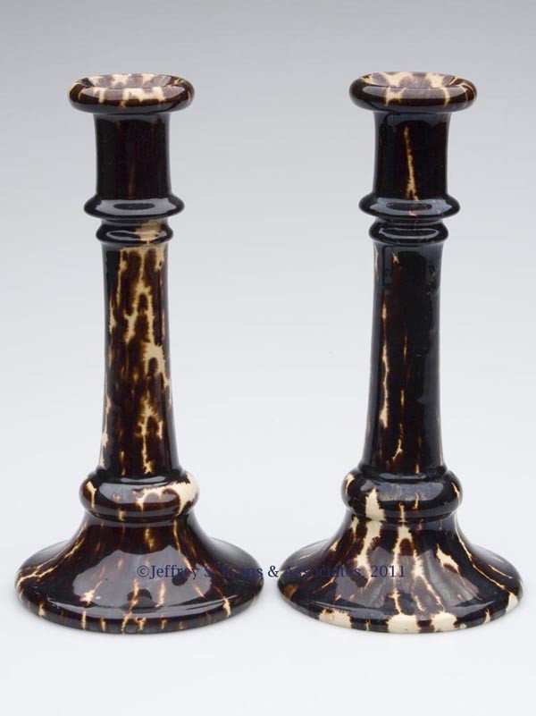 BENNINGTON-ATTRIBUTED ROCKINGHAM-GLAZE POTTERY PAI: BENNINGTON-ATTRIBUTED ROCKINGHAM-GLAZE POTTERY PAIR OF CANDLESTICKS, mottled dark brown, unmarked. Probably Lyman Fenton & Co., Bennington, VT. 1849-1858. 9 1/2" H, 4 1/2" D base. Literature: Barret's