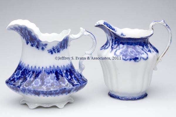 ENGLISH STAFFORDSHIRE TRANSFERWARE FLOW BLUE PITCH: ENGLISH STAFFORDSHIRE TRANSFERWARE FLOW BLUE PITCHERS, LOT OF TWO, each with trademark under base, one bearing the name "ROXBURY", by W. Ridgways; the other in an unidentified pattern by W. H. Grindle