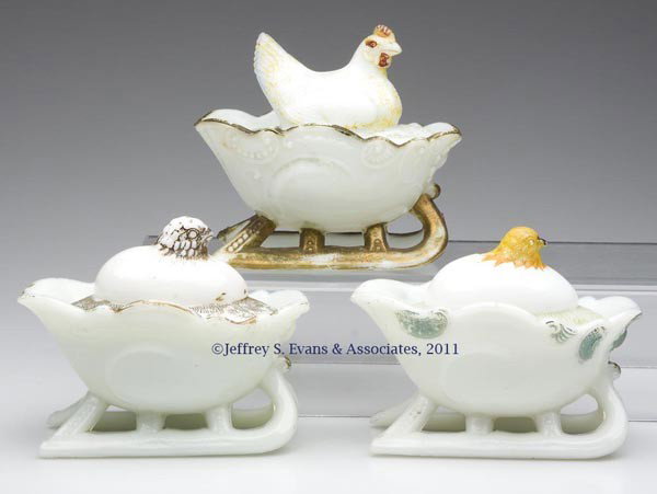 CHICKS / HEN ON SLEIGHS COVERED DISHES, LOT OF THRE: CHICKS / HEN ON SLEIGHS COVERED DISHES, LOT OF THREE, opaque white/milk glass, with varying degrees of original paint, comprising two chicks emerging from eggs and one hen, each on a scrolled sleigh. 