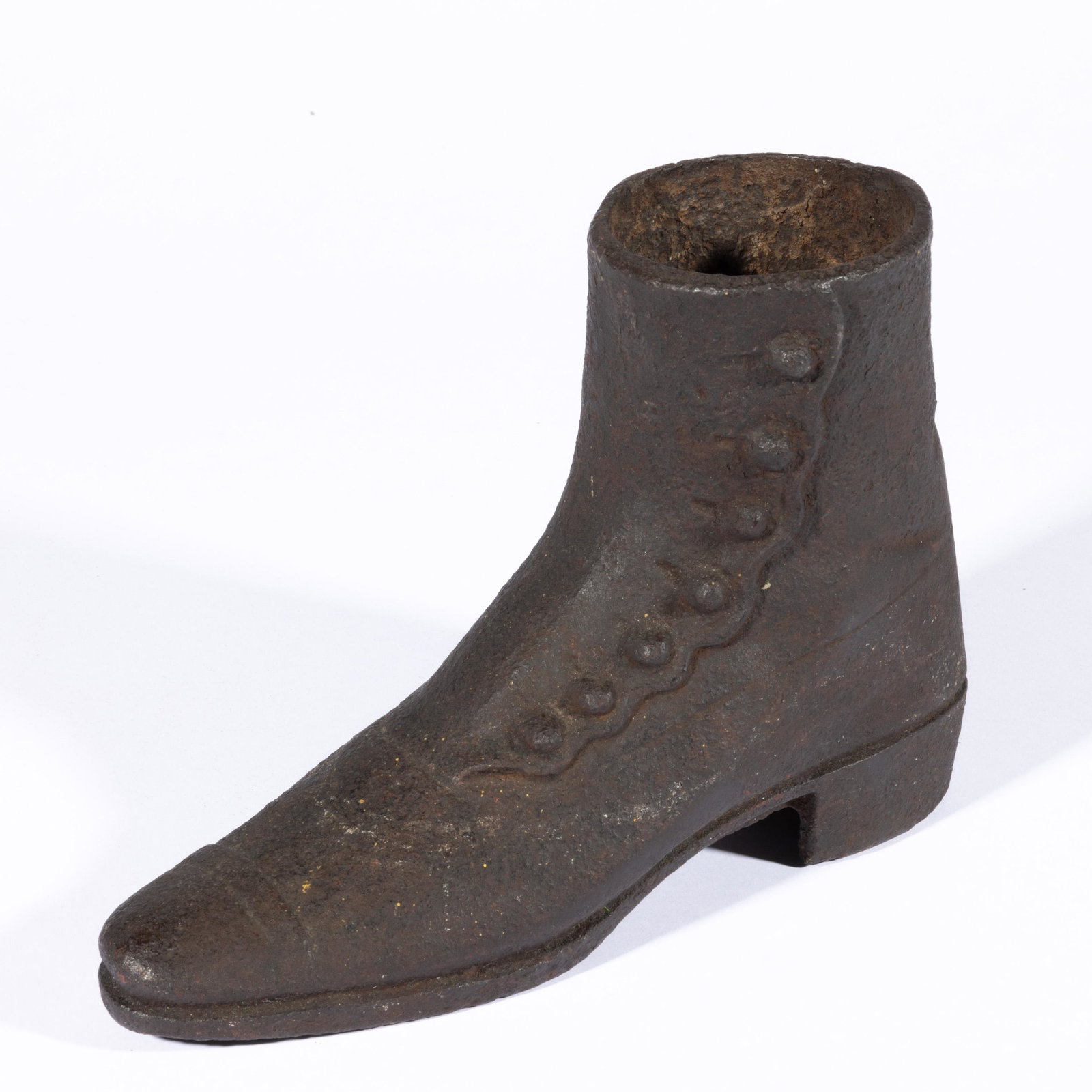 CAST-IRON HIGH-TOP SHOE FIGURAL DOORSTOP,: life-size with side buttons and slight heel. Fourth quarter 19th century. 6 1/2" H, 9 3/4" L. Provenance: Property of a Shenandoah Valley of Virginia lady.