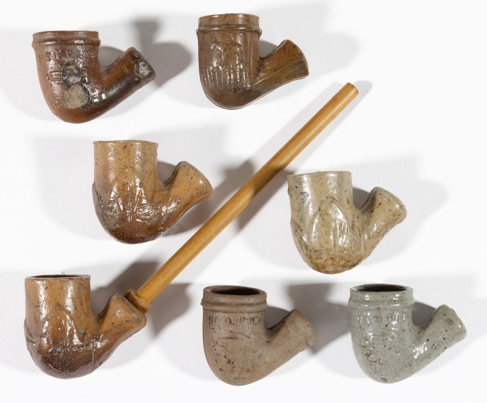 ASSORTED EMBOSSED ADVERTISING AND OTHER STONEWARE CLAY PIPES, LOT OF SEVEN, (1 of 2)