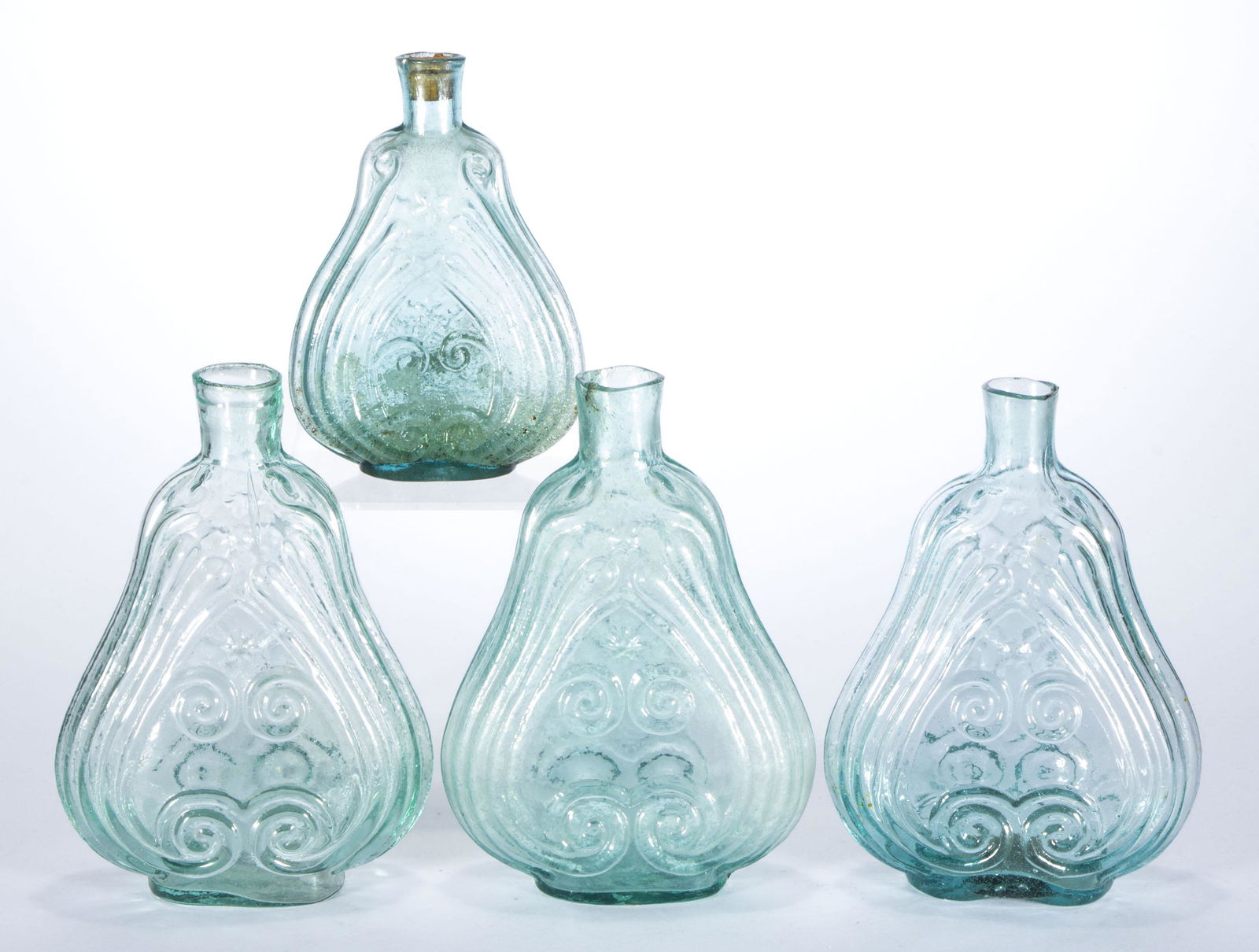 ASSORTED SCROLL FLASKS, LOT OF FOUR,: aquamarine and light green, comprising two pint GIX-11, one pint GIX-11a, and one half-pint GIX-31, each having a sheared mouth, one with tubular pontil mark, one with iron pontil, and two with rough